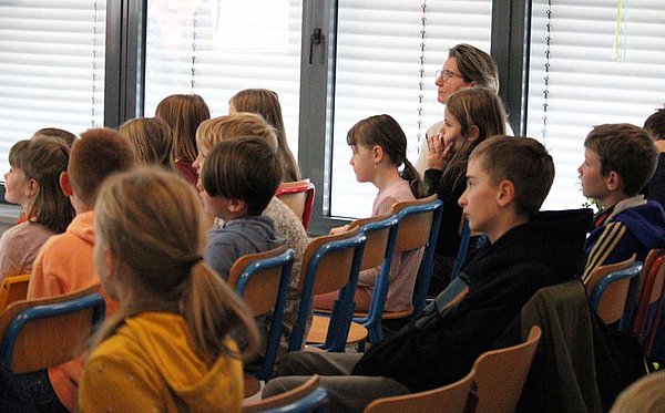 Kinder und Lehrende hören zu im Kinderhörsaal